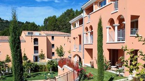 Ein mehrstöckiges Hotel mit einheitlichem Baustil, mit Balkonen und Rundbogenfenstern.