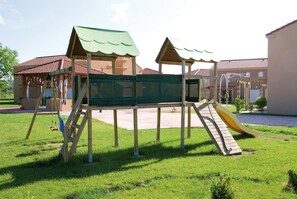Explore the fun of this playground with a climbing net, slide, and playhouse.