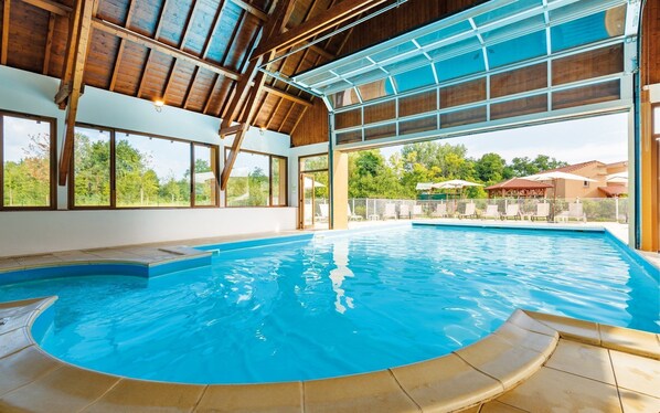 Swim surrounded by lush views and relax in the pool area with a glass ceiling.