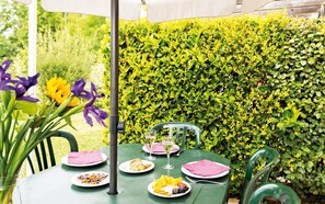 Enjoy a meal al fresco in this serene outdoor dining area surrounded by lush greenery.