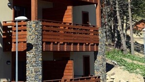 A multi-story building with wooden balconies and stone pillars.