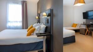 Une chambre d’hôtel avec deux lits, un bureau, une chaise, une télévision et une fenêtre avec des rideaux.