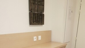 A bunk bed with a mattress and a shelf above.