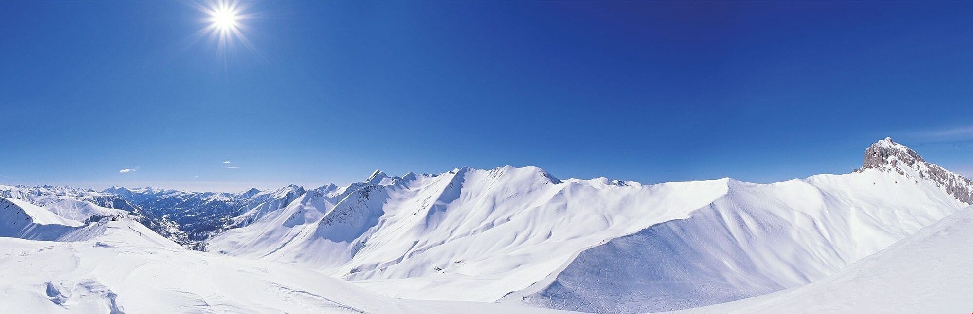 A snow-covered mountain landscape with clear skies.