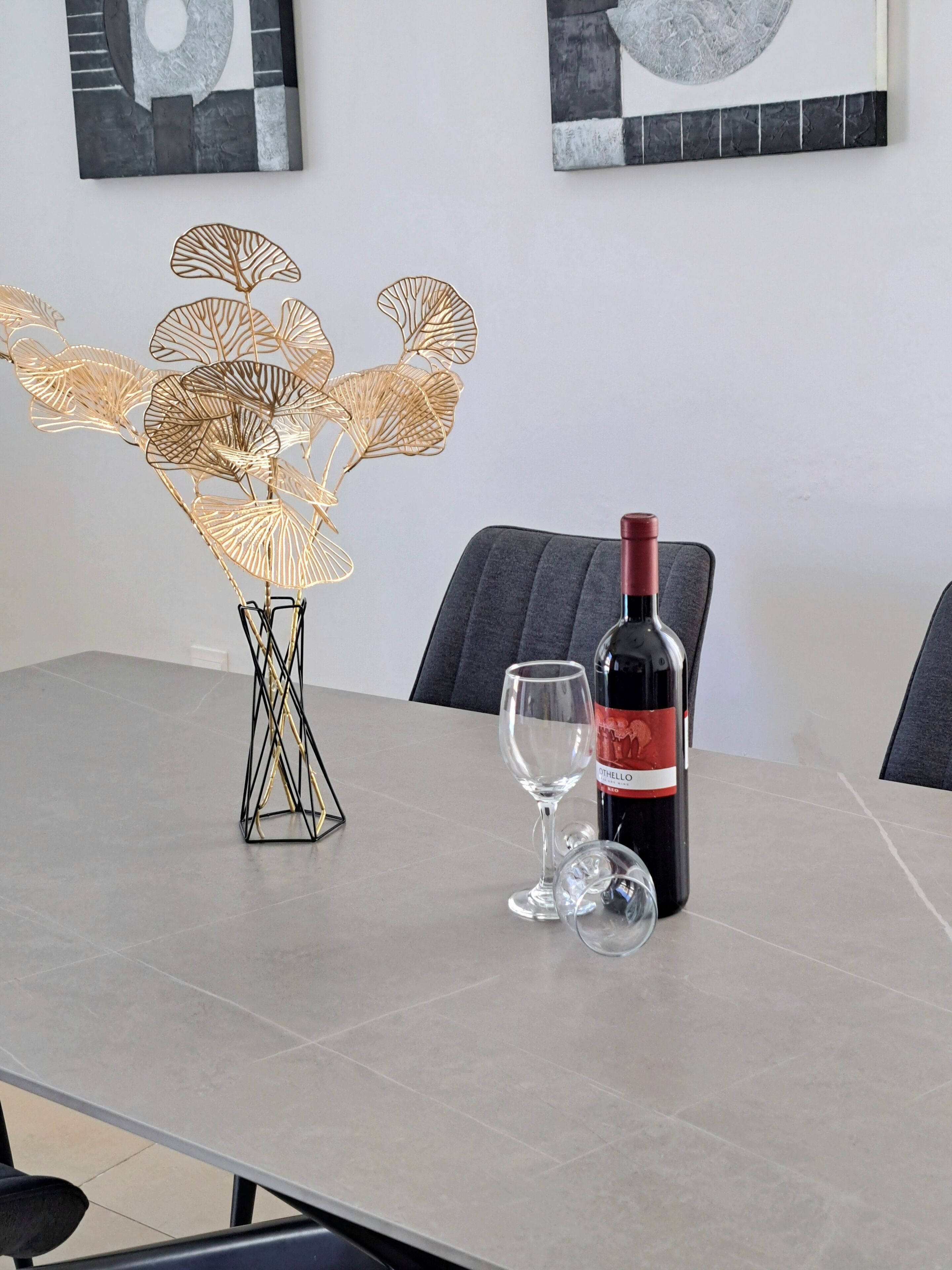 Une table à manger avec une bouteille de vin et deux verres à vin.