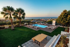 A pool area with a wooden deck, lounge chairs, and a view of the ocean. - VILLA PELAGOS VIEW,PRIVATE POOL,4 BEDROOM, 5 min from the beach! (Crete)