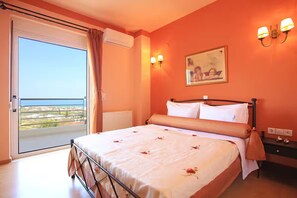 A bedroom with a bed, a nightstand, a wall-mounted lamp, and a window with a view. - VILLA PELAGOS VIEW,PRIVATE POOL,4 BEDROOM, 5 min from the beach! (Crete)