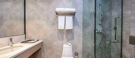Une salle de bain moderne avec une douche à parois de verre, des toilettes et un meuble-lavabo avec un évier.