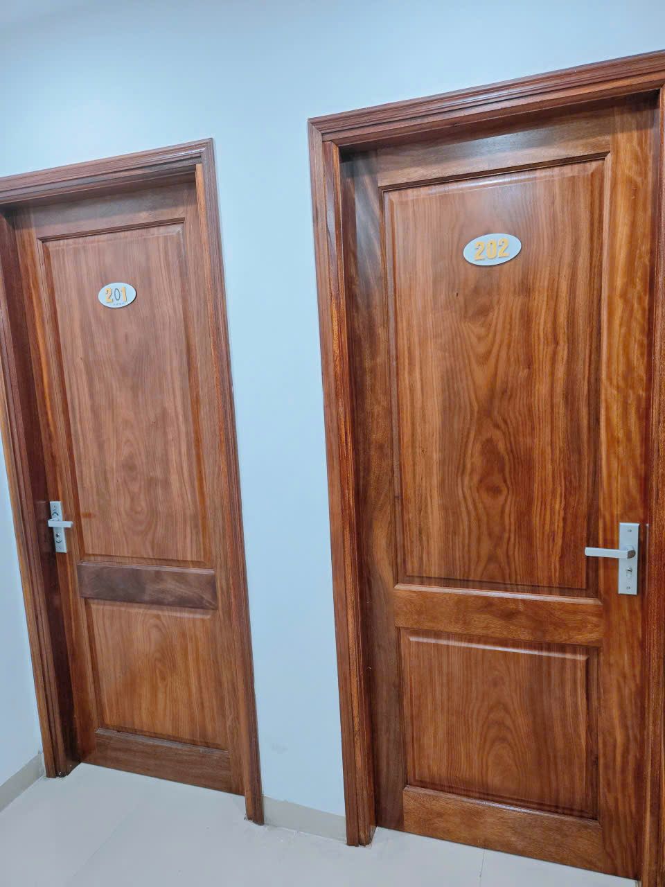 Two wooden doors with labels, one with a number '201' and the other with '202'.