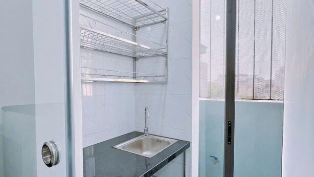 A modern bathroom with a glass shower enclosure, a sink, and a marble floor. - Heart Home (Hanoi)