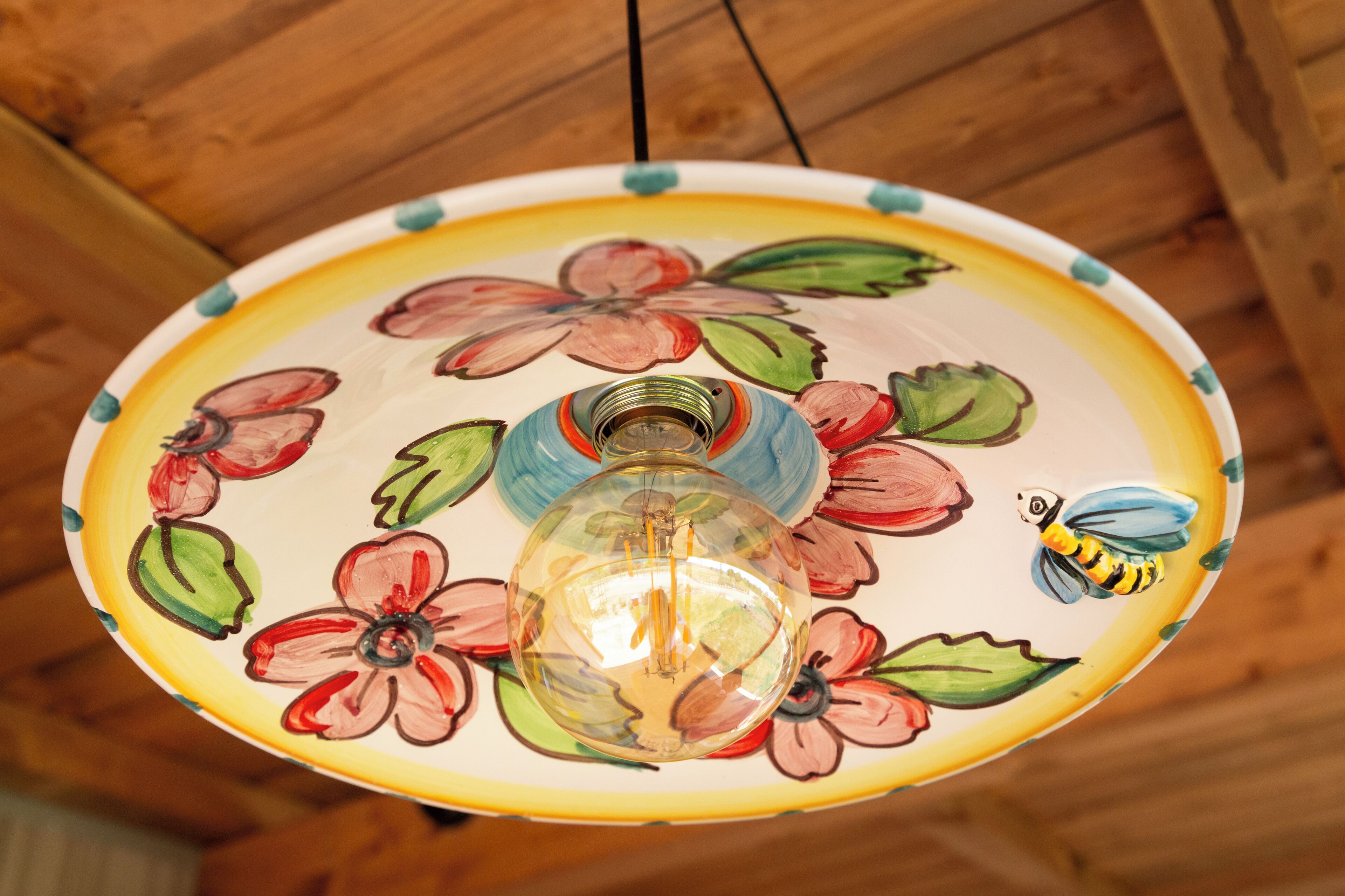 Un luminaire de plafond orné d’un motif floral et d’une illustration d’abeille.