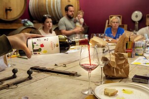 Degustación de vinos, con énfasis en el servicio de una botella en una copa.