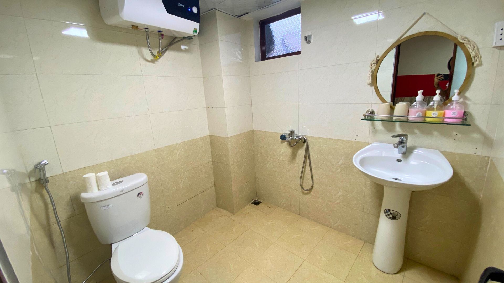 Ein kleines, sauberes Badezimmer mit Toilette, Waschbecken und Dusche.