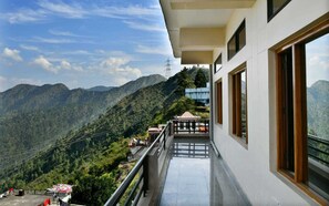 A balcony with a view of a mountainous landscape. - Hotel Mount Pleasant (Pauri)