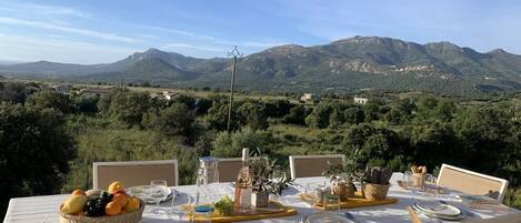 A table set for dining with a mountain view in the background.