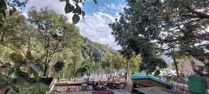 Ein See-Restaurant mit Terrassensitzgelegenheiten, umgeben von Bäumen und Seeblick.