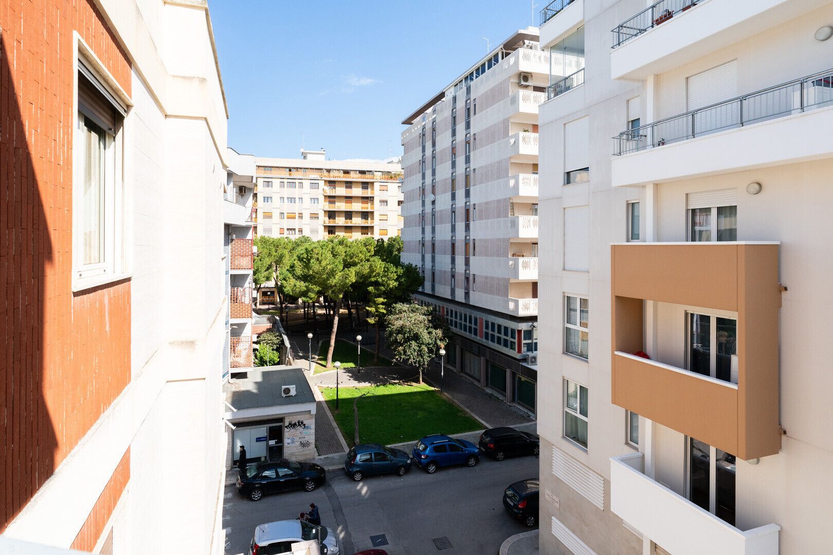 Un immeuble résidentiel à plusieurs étages doté d’une cour intérieure, de balcons et d’un espace de stationnement.