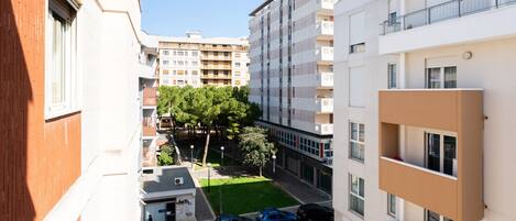 Un immeuble résidentiel à plusieurs étages doté d’une cour intérieure, de balcons et d’un espace de stationnement.