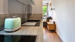 Une cuisine moderne équipée d’une cuisinière intégrée, d’un évier et d’un coin repas compact avec une table et des chaises.