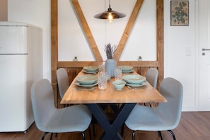 A dining table with light blue chairs, a wooden table, and a hanging light fixture. - Apartment 'Ferienwohnung Am Mehlberg' with Shared Terrace and Wi-Fi (Hinterzarten)