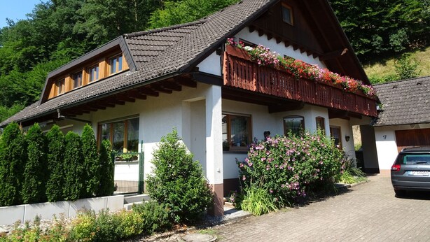 A traditional chalet with a sloped roof, wooden balcony, and flower boxes. - Apartment 'Mühlengrün' with Mountain View, Balcony and Wi-Fi (Oberwolfach)