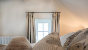 Un dormitorio con ventana, cortinas y un radiador.