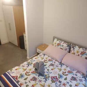 A bedroom with a bed, a nightstand, a dresser, and a door. - Central 1 Bed-self Checkin, Min-arena, 7d-discount (Manchester)