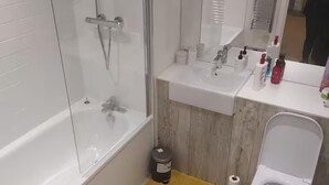 Ein Badezimmer mit Duschkabine, Waschbecken und Toilette.