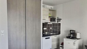 Eine kleine Küche mit Mikrowelle, Spüle und Kaffeemaschine.