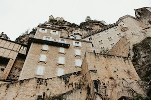 Un edificio histórico de piedra con múltiples ventanas y una torre.
