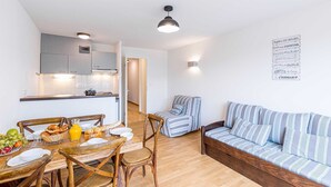 Un apartamento moderno con comedor, kitchenette y sala de estar con sofá a rayas.