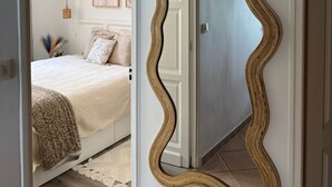 A bedroom with a bed, a large mirror, and a door leading to another room. - Le Paradis Marin (Saint-Cyr-sur-Mer)