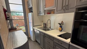 A modern kitchen with grey cabinets, a stainless steel sink, and an oven. - Le Paradis Marin (Saint-Cyr-sur-Mer)
