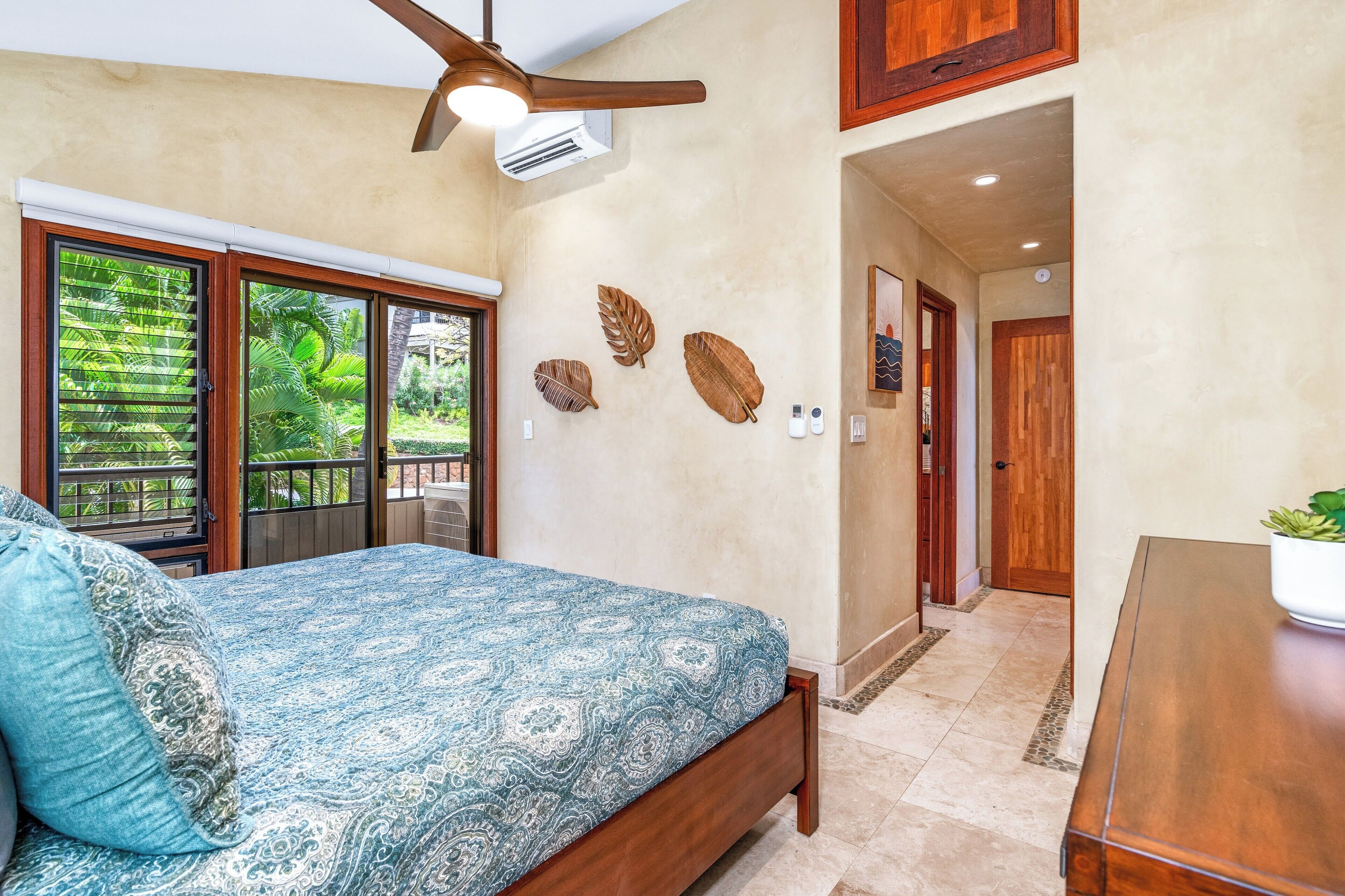 A bedroom with a bed, a ceiling fan, a window with blinds, and a wall-mounted air conditioner.