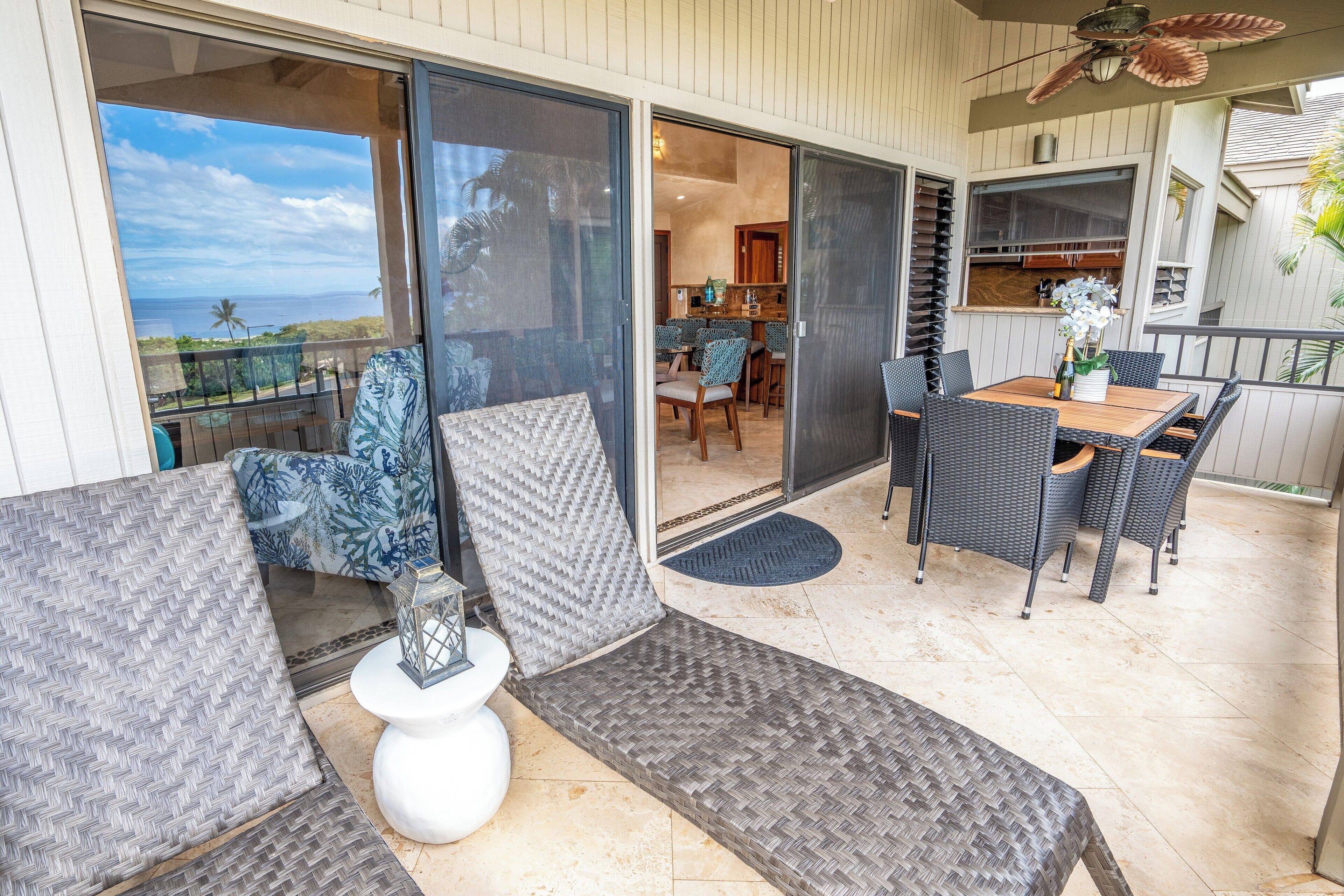 A covered outdoor area with a dining table, chairs, and a sofa.