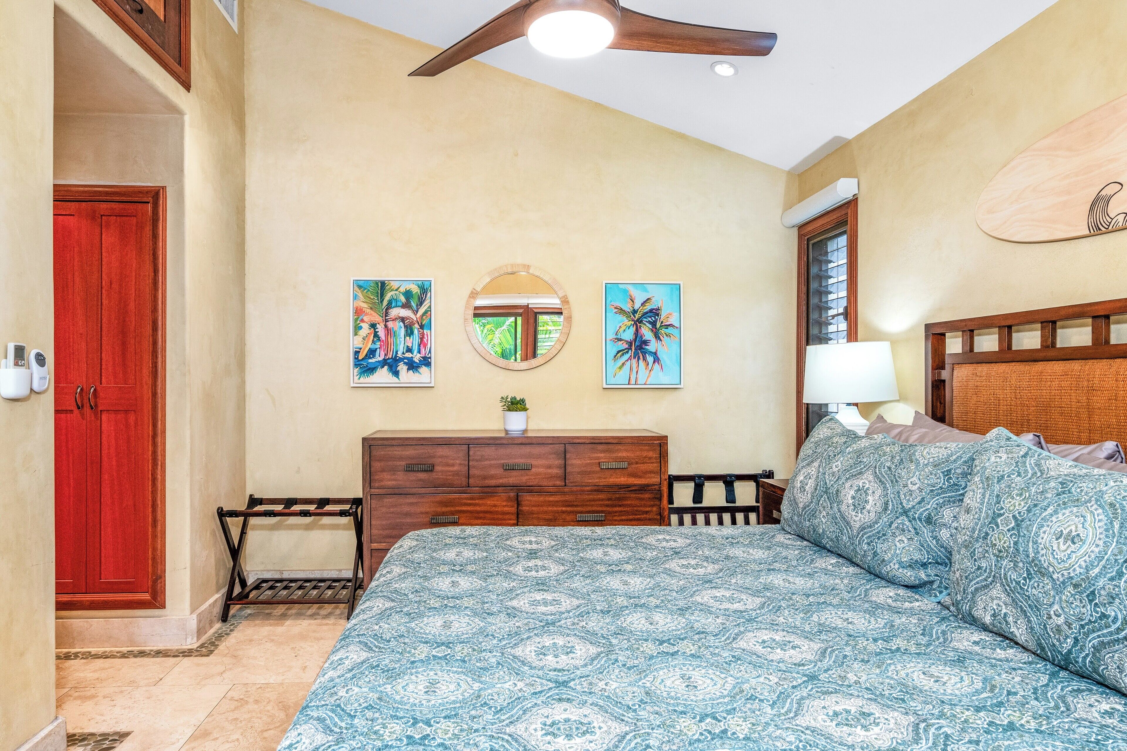 Un dormitorio con cama, cómoda de madera y una obra de arte en la pared.
