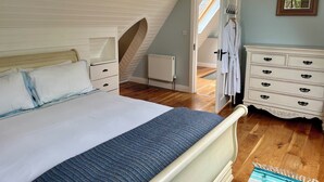 A bedroom with a bed, a dresser, and a radiator.