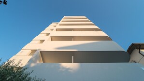Un edificio moderno con varias balcones y ventanas, visto desde abajo.