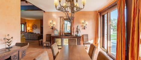 Enjoy meals in this well-lit dining area with a long table and comfortable chairs.