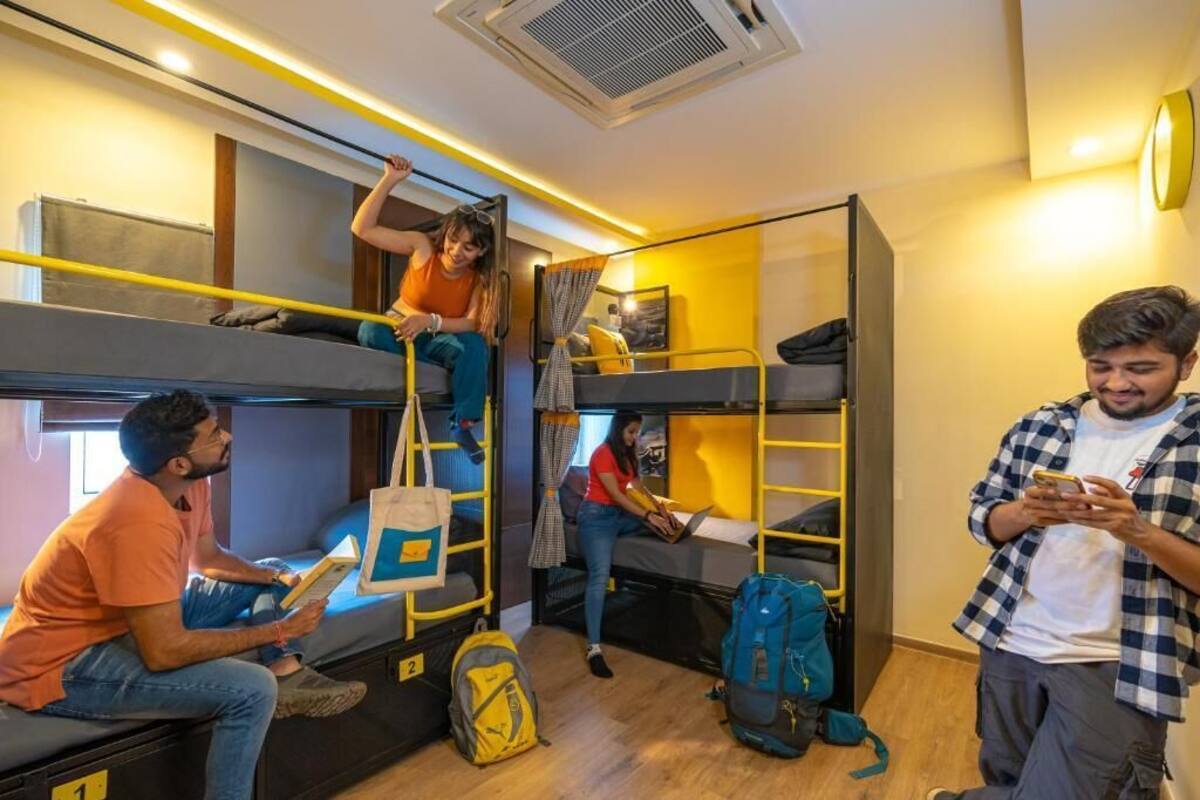 Ein Schlafsaalzimmer mit Etagenbetten, einem Fenster und einer Tür.