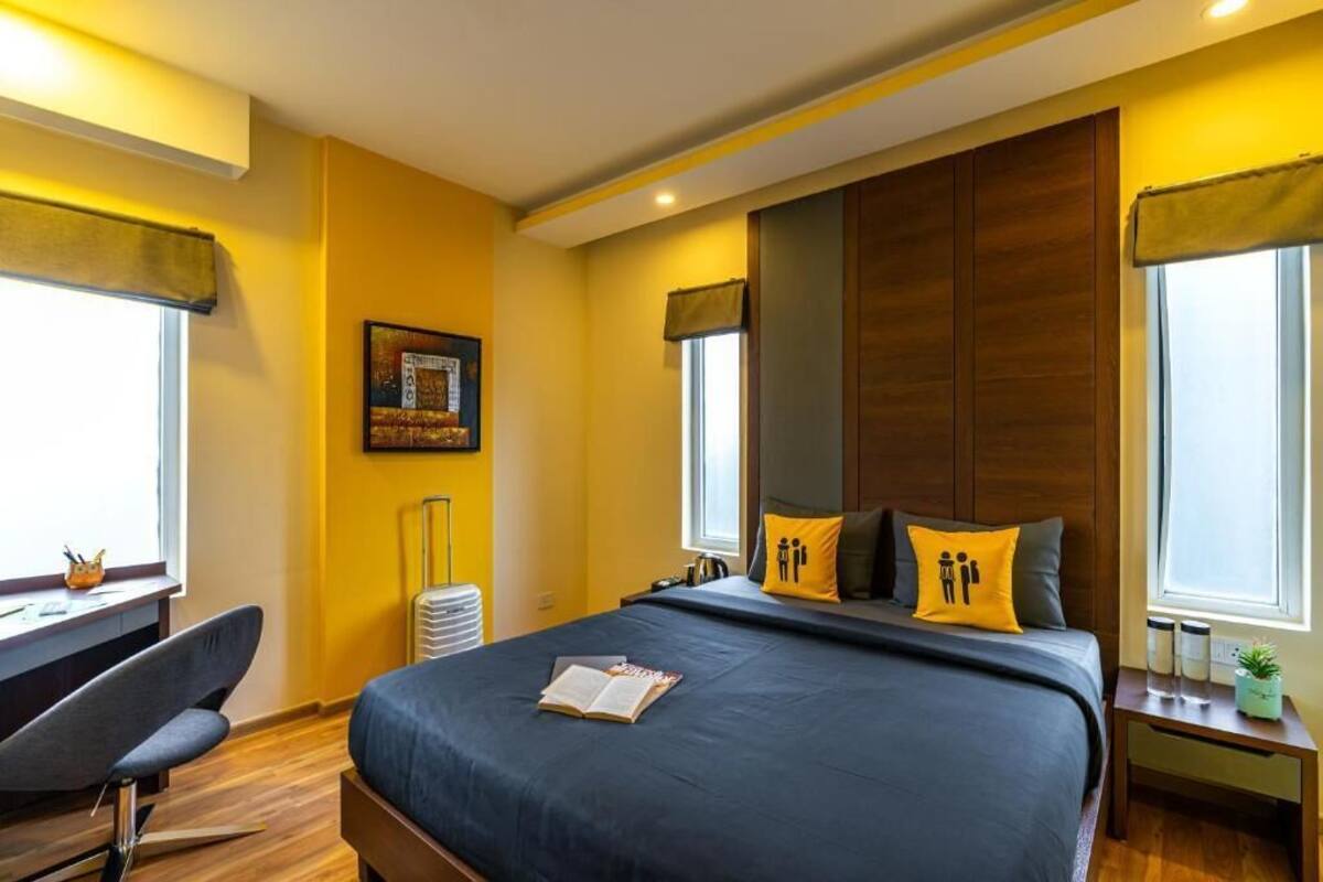 Ein modernes Hotelzimmer mit einem großen Bett, einem Schreibtisch und einem Sessel.
