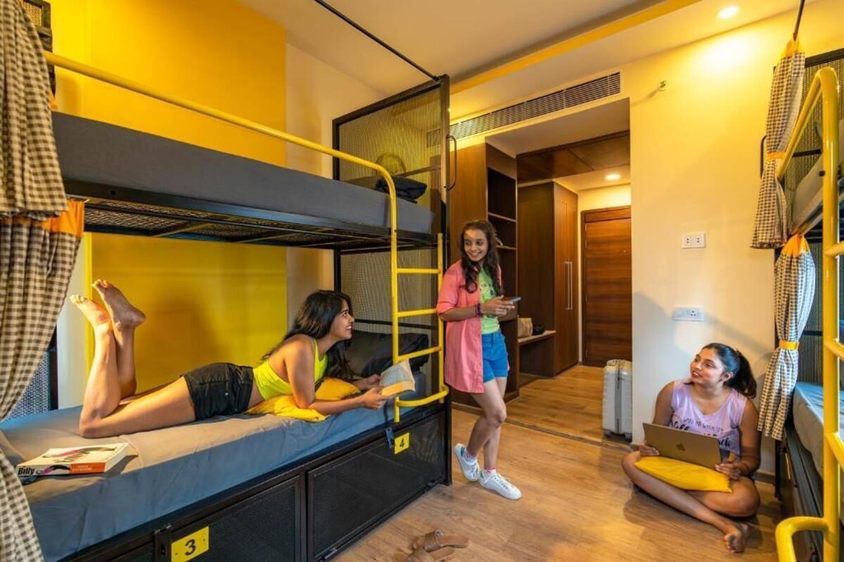 Ein Schlafsaalzimmer mit Etagenbetten, einem kleinen Schreibtisch und einem Stuhl.