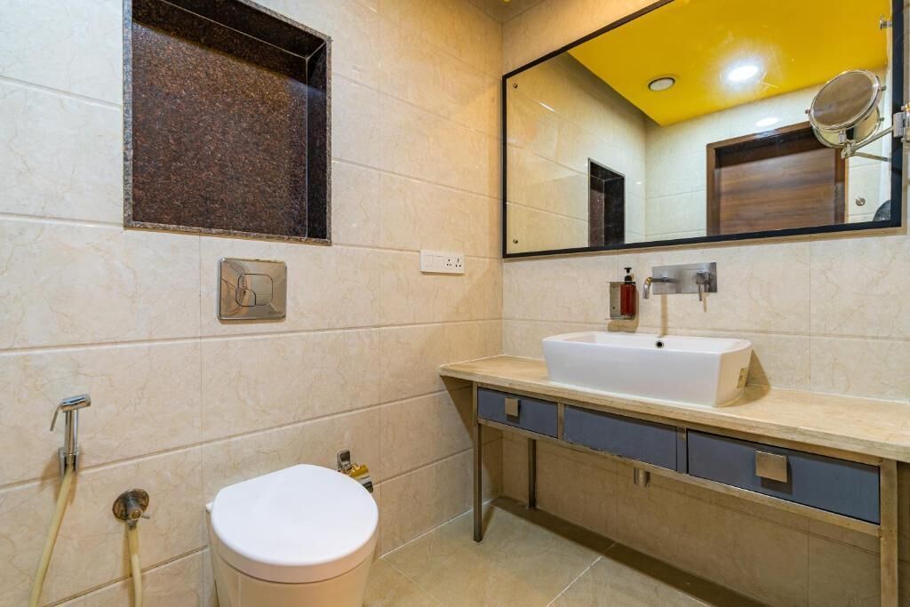 A bathroom with a toilet, sink, mirror, and towel rack.