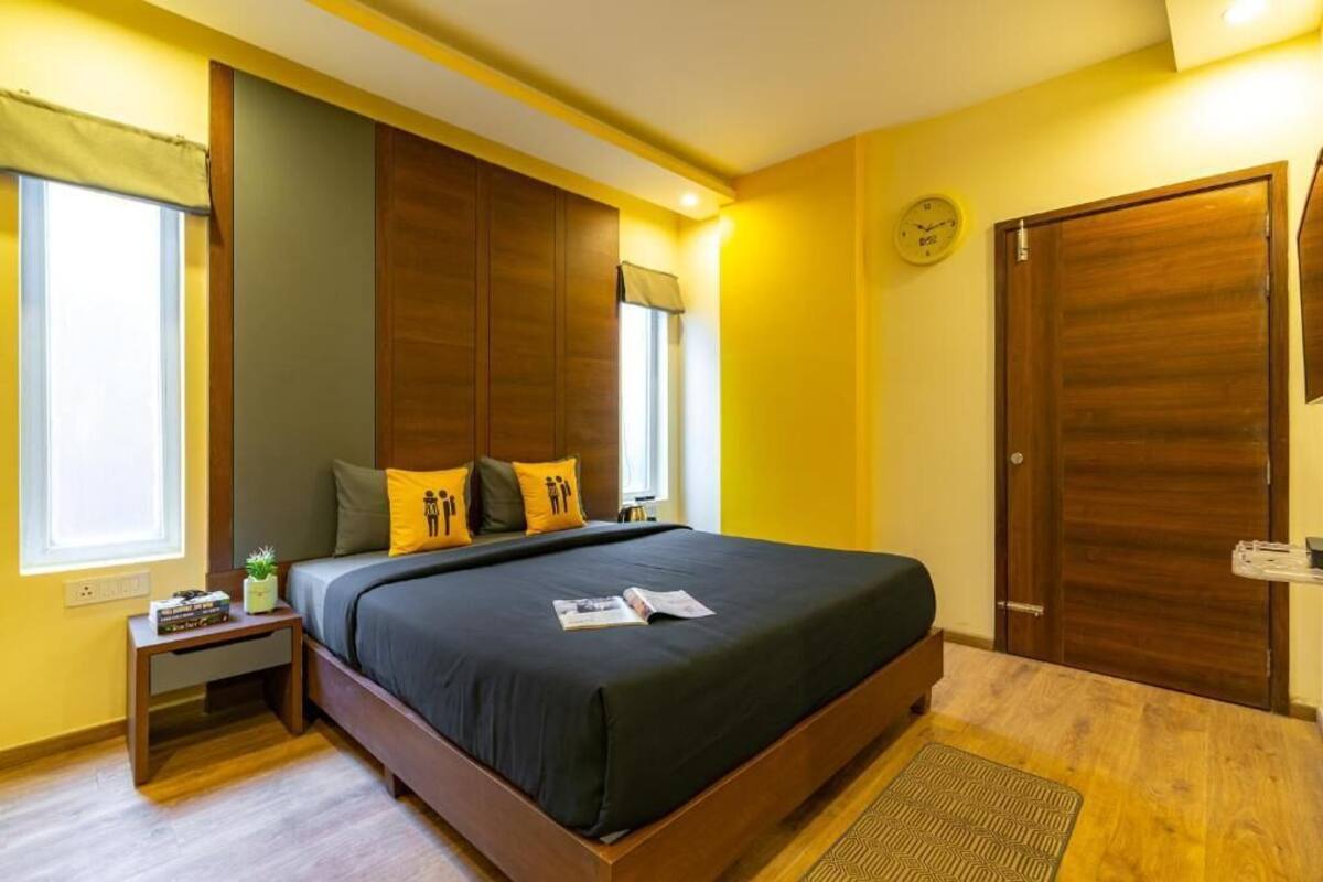 Ein Schlafzimmer mit einem großen Bett, einem Holzschrank und einem kleinen Nachttisch mit einer Pflanze.
