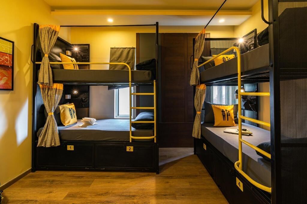 A dormitory room with bunk beds, numbered beds, and curtains.