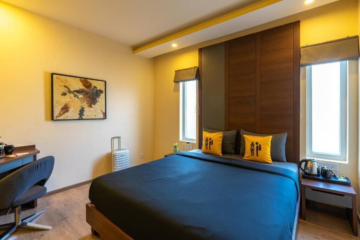 Ein modernes Hotelzimmer mit einem großen Bett, einem Schreibtisch und einem Sessel.