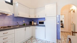 A kitchen with white cabinets, a blue tiled backsplash, a microwave, and a sink. - My Rental Homes - Casa Li Galli  5mins' walk from Positano center, terrace, sea view (Positano)