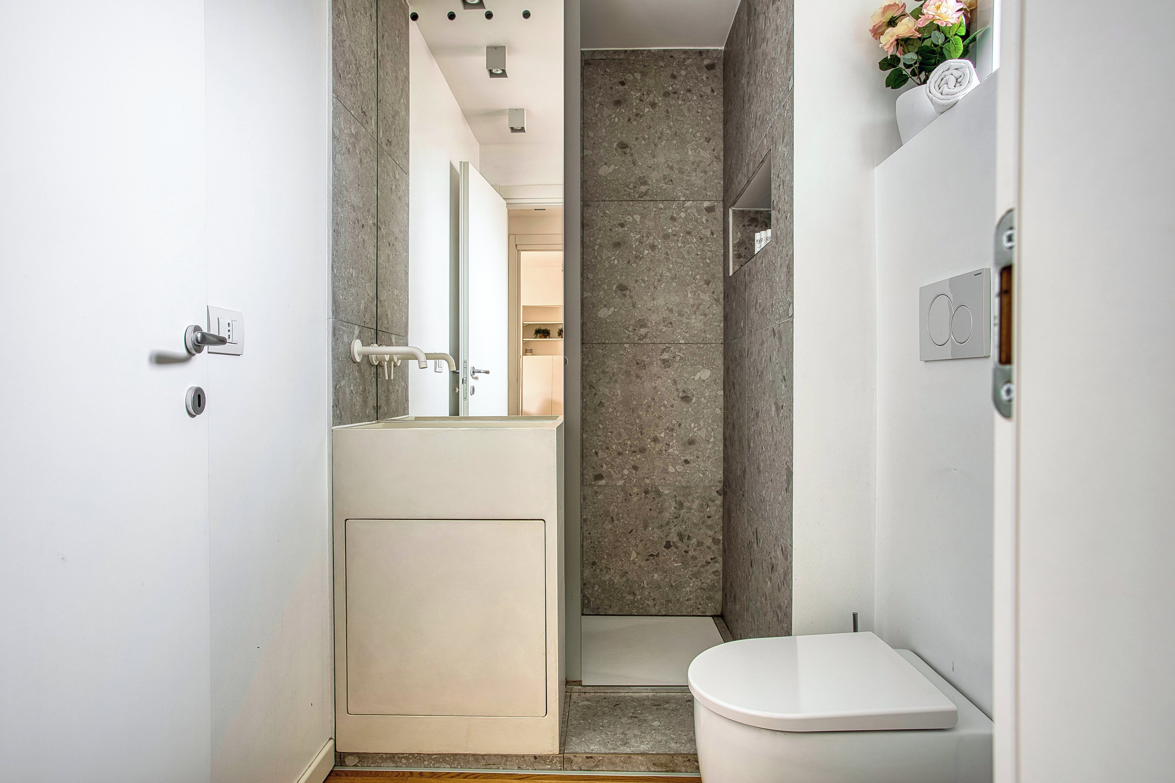 Et moderne badeværelse med bruser, toilet og vask.