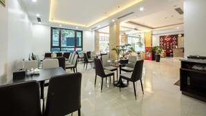 A modern dining area with tables and chairs, large windows, and a reception desk. - A25 Hotel - Hoang Dao Thuy 2 (Hanoi)