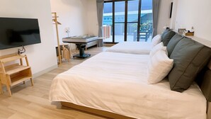 Une chambre d’hôtel avec deux lits, une télévision, un bureau et une vue sur l’extérieur.